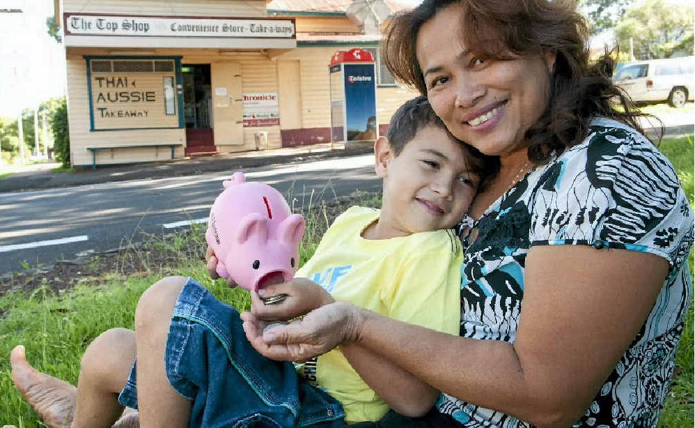 HELPING OUT: Kali Stack, 6, cheers up his mum Janya by giving her his piggy bank money after the family’s shop was robbed. HELPING OUT: Kali Stack, 6, cheers up his mum Janya by giving her his piggy bank money after the family’s shop was robbed.
