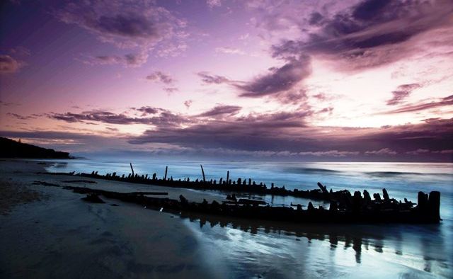 REMAINS OF WRECK: The shipwreck of the Buster has been uncovered again on Woolgoolga's main beach by big seas. REMAINS OF WRECK: The shipwreck of the Buster has been uncovered again on Woolgoolga's main beach by big seas.