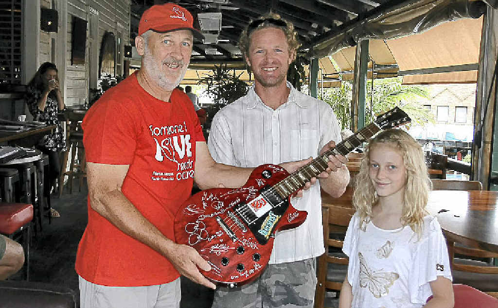TREASURE: Dave Godfrey picks up his signed Gibson Les Paul Studio guitar with daughter Misty from Cystic Fibrosis charity co-ordinator Alan Tunks at The Balcony. TREASURE: Dave Godfrey picks up his signed Gibson Les Paul Studio guitar with daughter Misty from Cystic Fibrosis charity co-ordinator Alan Tunks at The Balcony.