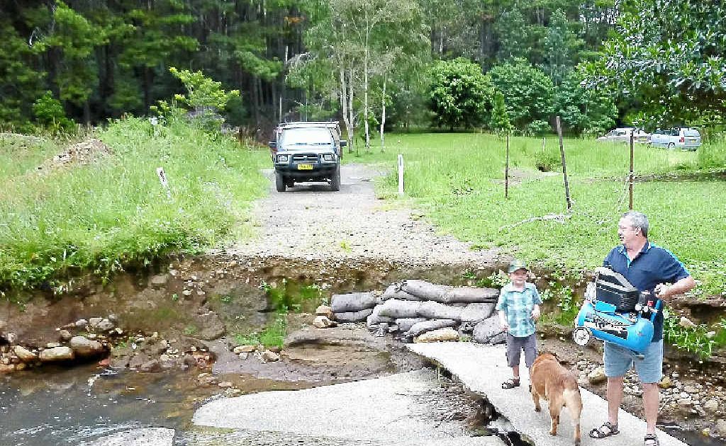 Jim Reimer, 7-year-old son Connor and dog Sabre on the destroyed causeway he and his family used to drive across to get home. Jim Reimer, 7-year-old son Connor and dog Sabre on the destroyed causeway he and his family used to drive across to get home.