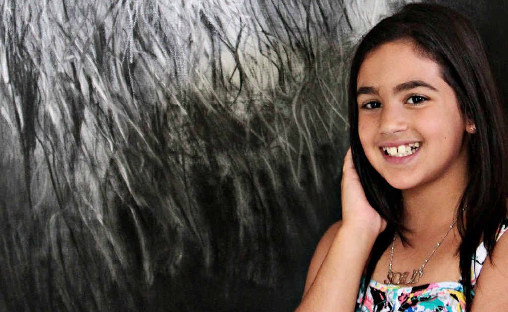 Tia Elsayed, 10, with her charcoal drawing of a lion. Tia Elsayed, 10, with her charcoal drawing of a lion.