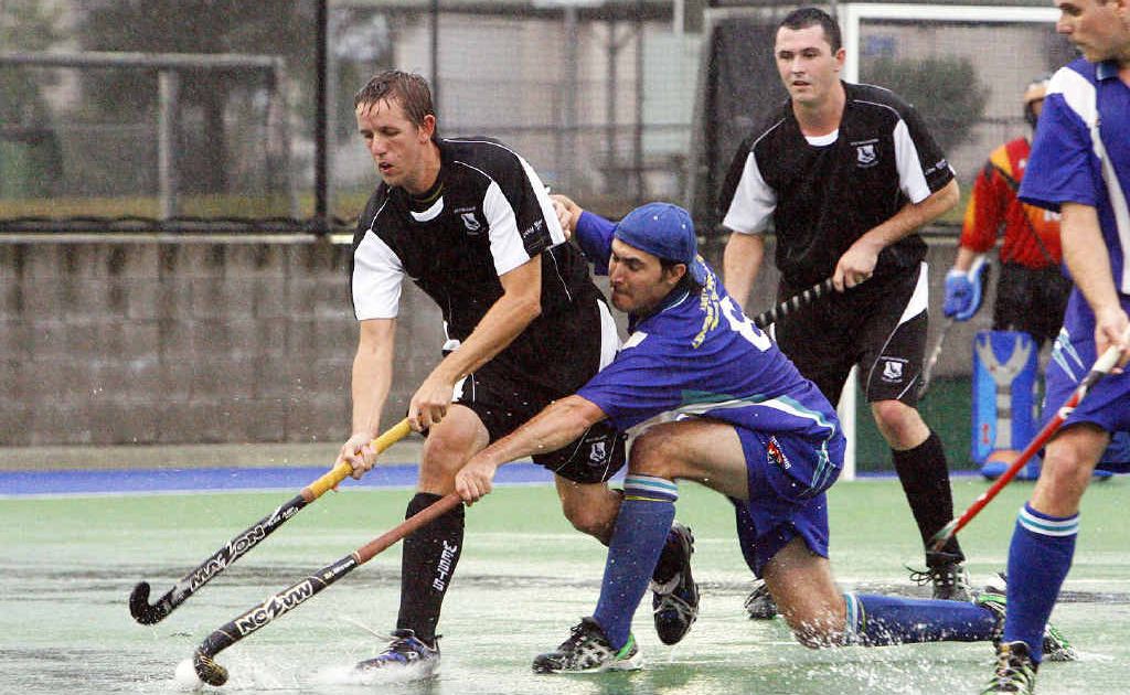 Wests playmaker Todd Watson works hard for possession against a Toowoomba Newtown challenger in Saturday’s difficult playing conditions at the Ipswich Hockey Complex. Wests playmaker Todd Watson works hard for possession against a Toowoomba Newtown challenger in Saturday’s difficult playing conditions at the Ipswich Hockey Complex.