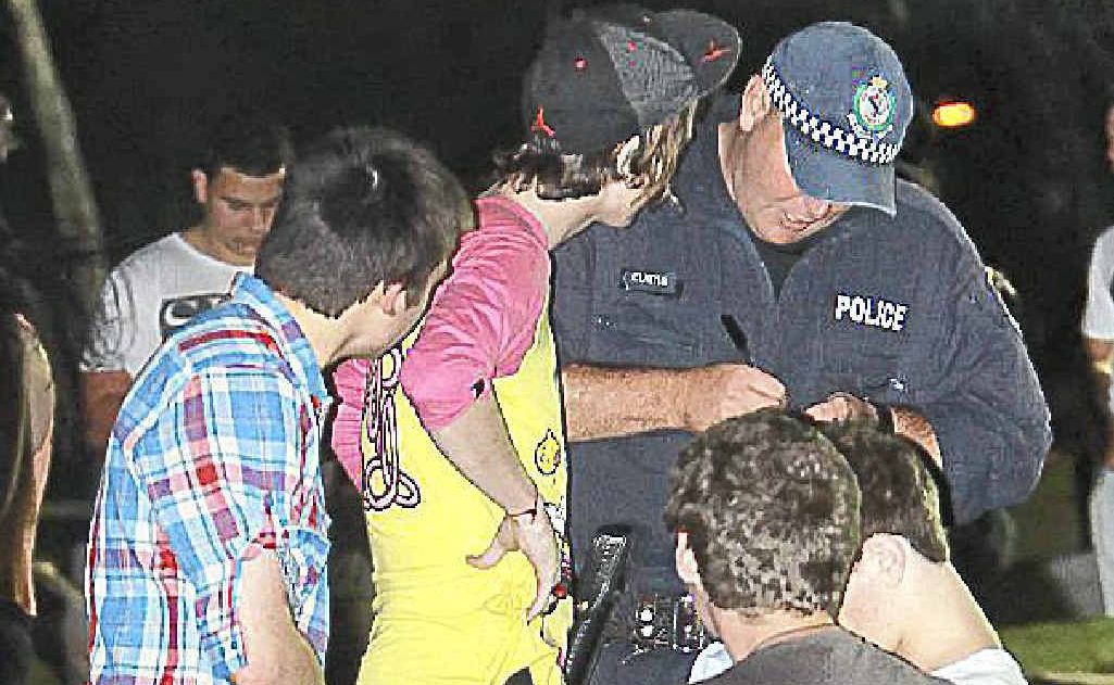 Police speaking with youths in a Byron Bay park. Police speaking with youths in a Byron Bay park.