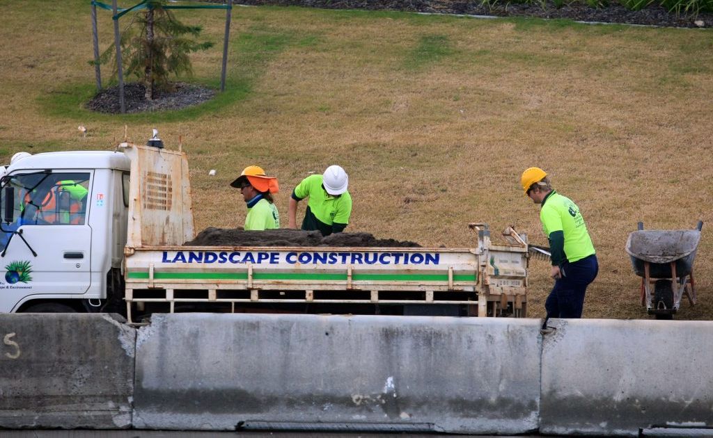 Workers lay turf at the Banora Point Upgrade site. Workers lay turf at the Banora Point Upgrade site.