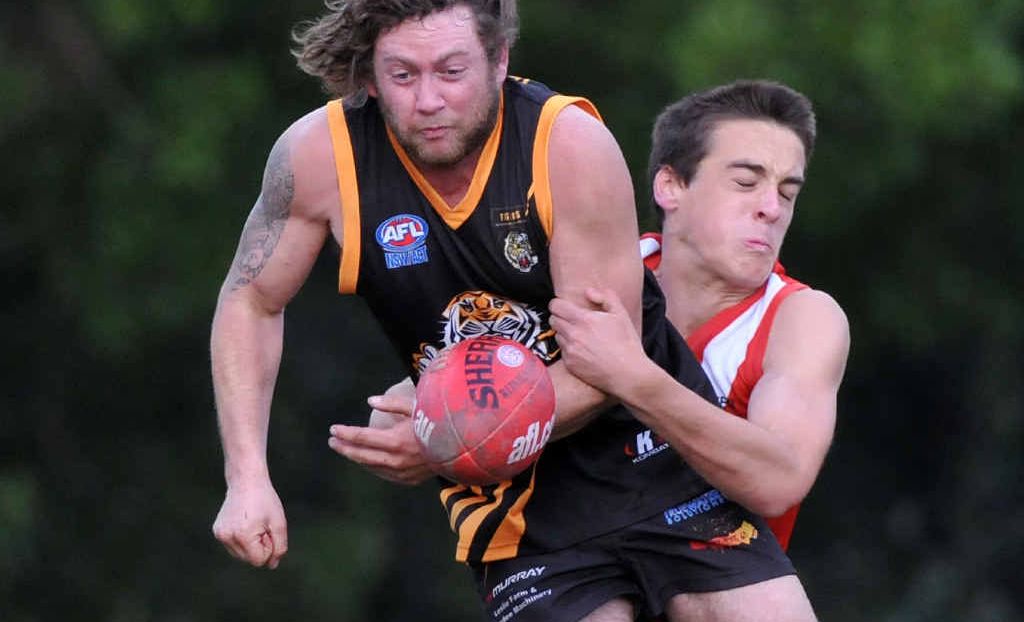 Grafton Tigers’ Ronald Davis gets the ball away despite the best efforts of a Coffs Swans defender at Fitzroy Oval on Saturday. Grafton Tigers’ Ronald Davis gets the ball away despite the best efforts of a Coffs Swans defender at Fitzroy Oval on Saturday.