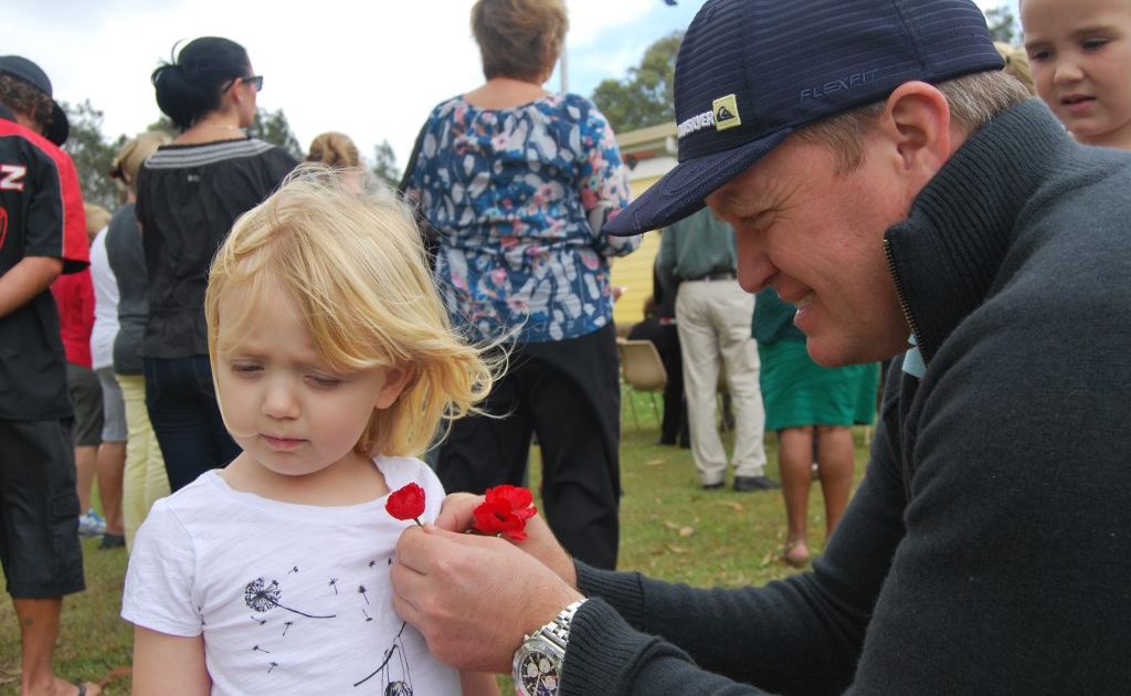 Simon Phillips pins a poppy on daughter Sadie at the Pottsville Remembrance Day on Sunday. Simon Phillips pins a poppy on daughter Sadie at the Pottsville Remembrance Day on Sunday.