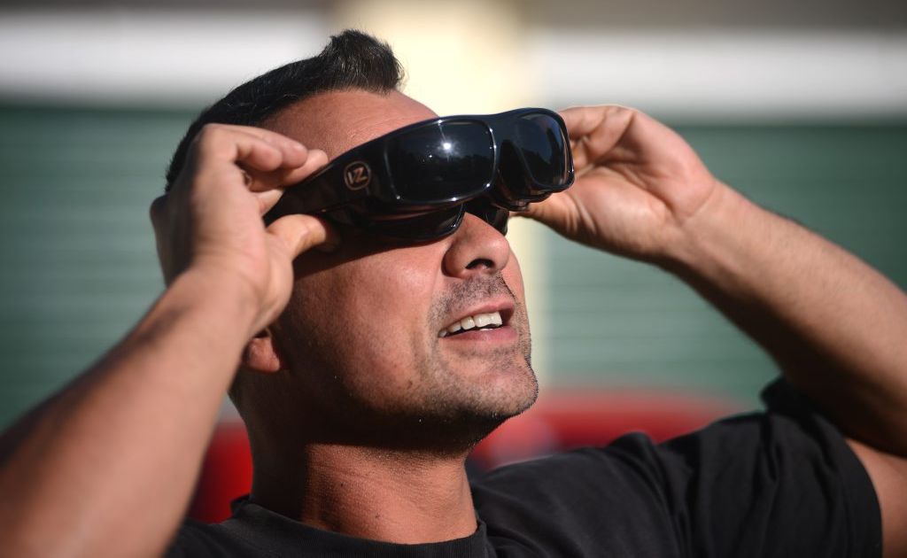 Joe Murphy, of Currumbin, looks through six pairs of sunglasses to view the eclipse. Joe Murphy, of Currumbin, looks through six pairs of sunglasses to view the eclipse.