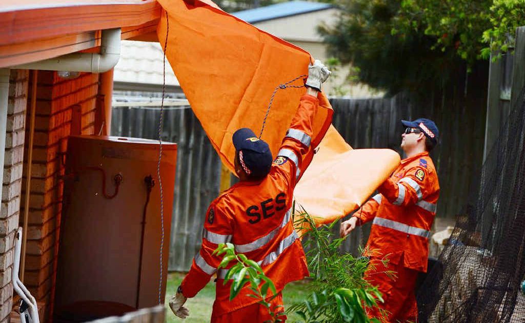 DAMAGE COVER: SES crews cover the damaged roof of a house in Deebing Heights after it was struck by lightning on Saturday. DAMAGE COVER: SES crews cover the damaged roof of a house in Deebing Heights after it was struck by lightning on Saturday.