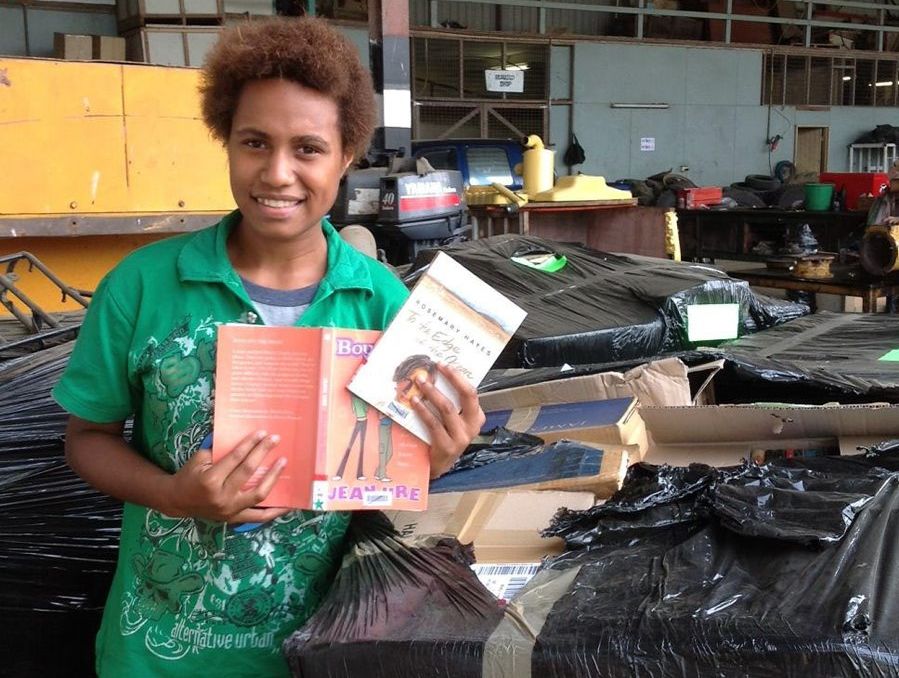 Vanessa Andy, a student in Papua New Guinea, admires the donated books. Photo: Contributed Vanessa Andy, a student in Papua New Guinea, admires the donated books. Photo: Contributed