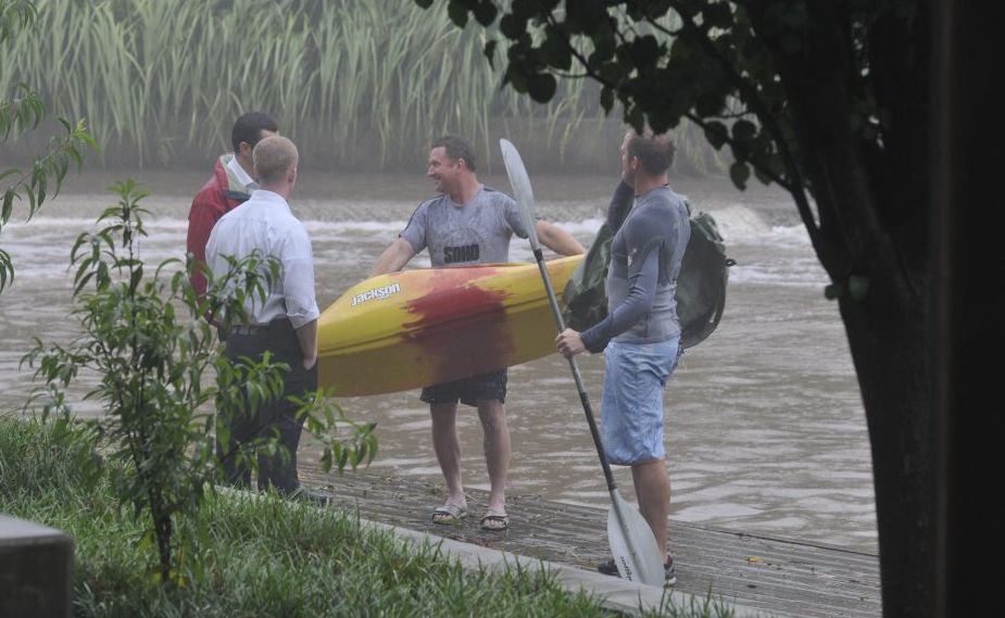 Two plain-clothes detectives tell West Creek paddlers to move along as the rain pours down on Australia Day. Two plain-clothes detectives tell West Creek paddlers to move along as the rain pours down on Australia Day.