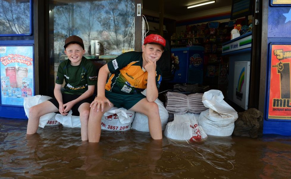 Taylor and Parker Bryant on some sand bags in front of Chinderah News. Taylor and Parker Bryant on some sand bags in front of Chinderah News.