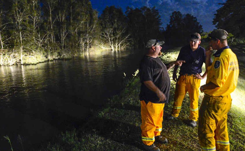 WATCHING BRIEF: Rural Fire Service volunteers check the top of the levee for heights and any weakness as the Clarence River rises in darkness at Maclean. WATCHING BRIEF: Rural Fire Service volunteers check the top of the levee for heights and any weakness as the Clarence River rises in darkness at Maclean.