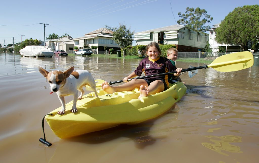 Louise and Jacob Watson with freckles the dog outside their grandmothers home in Depot Hill as the Fitzroy River approaches 8.6m in February this year. Grandmother bought kayak after last flood so she could get to the shops. Louise and Jacob Watson with freckles the dog outside their grandmothers home in Depot Hill as the Fitzroy River approaches 8.6m in February this year. Grandmother bought kayak after last flood so she could get to the shops.