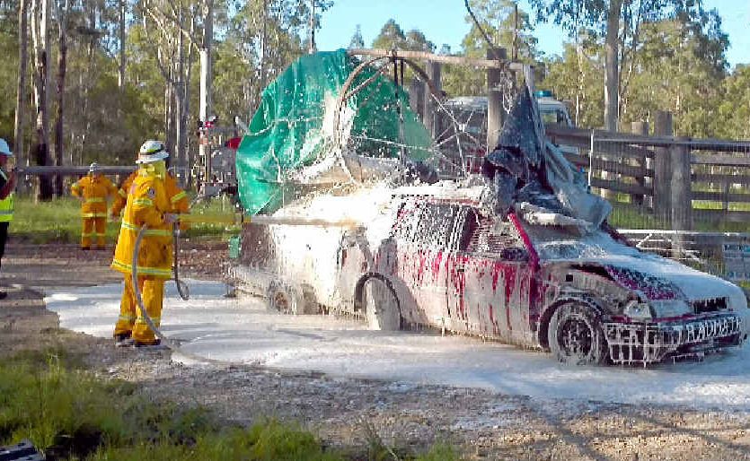 FOAMING WITH RAGE: The ’Mad Max’ car blocking the gate at Glenugie gets a precautionary foaming from the RFS. FOAMING WITH RAGE: The ’Mad Max’ car blocking the gate at Glenugie gets a precautionary foaming from the RFS.