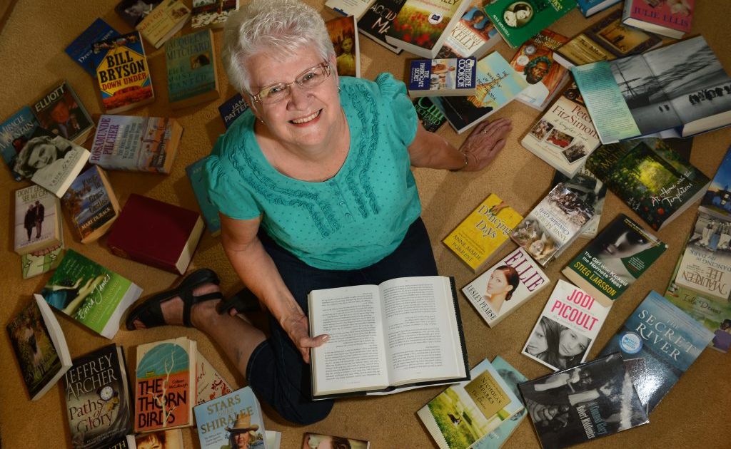 Christine Smith with heaps of books for sale to raise funds for cancer. Christine Smith with heaps of books for sale to raise funds for cancer.