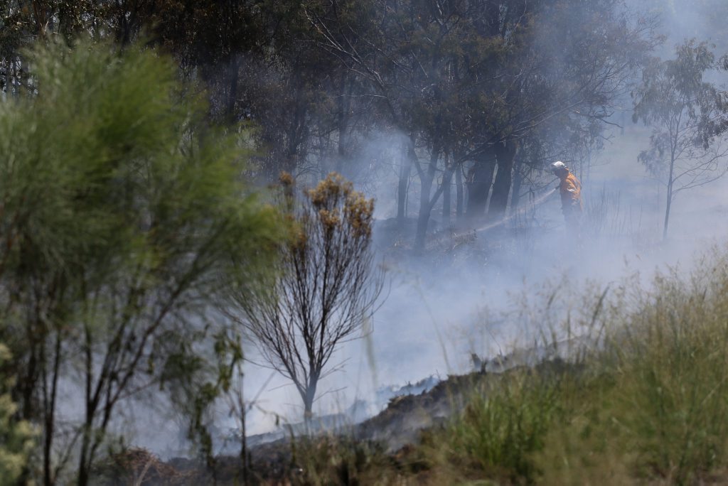 MOPPING UP: Rural fire crews hose down the site of a grass fire beside the Bunya Hwy at Taabinga. MOPPING UP: Rural fire crews hose down the site of a grass fire beside the Bunya Hwy at Taabinga.