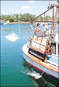 TO THE RESCUE: Peter McHunter, left, skipper of trawler The Piper J, and deckhand Mike Wilkes, tow the upturned runabout TO THE RESCUE: Peter McHunter, left, skipper of trawler The Piper J, and deckhand Mike Wilkes, tow the upturned runabout