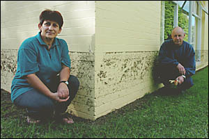 HEIGHT OF PAIN: Laura Child with the flood mark on the wall of her house in Helen Street, South Golden Beach. The levee beside HEIGHT OF PAIN: Laura Child with the flood mark on the wall of her house in Helen Street, South Golden Beach. The levee beside