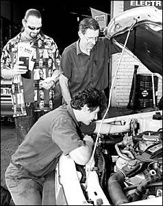 BONUS: At RA?s Lismore Car Repairs, customer Rodney Cooney with his petrol vouchers and business owners Andrew Robinson, fixing BONUS: At RA?s Lismore Car Repairs, customer Rodney Cooney with his petrol vouchers and business owners Andrew Robinson, fixing