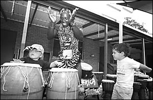 Sunday Ali from performer group, Jambo Africa, accompanies young Thomas Ferguson trying his hands at African drums, while Cody Sunday Ali from performer group, Jambo Africa, accompanies young Thomas Ferguson trying his hands at African drums, while Cody