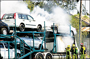 SMOKING CAR CARRIER: The prime mover of this Melbourne truck driver?s rig mysteriously burst into flames when he pulled up in L SMOKING CAR CARRIER: The prime mover of this Melbourne truck driver?s rig mysteriously burst into flames when he pulled up in L