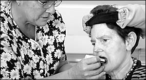 Carer Helen McIntyre applies lipstick for Isobel Bowden, a motor neurone disease (MND) sufferer, who is raising money for resea Carer Helen McIntyre applies lipstick for Isobel Bowden, a motor neurone disease (MND) sufferer, who is raising money for resea