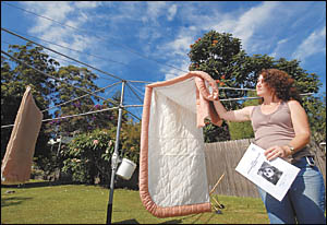 Gillian Hobson pulls her washing off the line ahead of the nightly exodus of flying foxes. She says the proposed measures are e Gillian Hobson pulls her washing off the line ahead of the nightly exodus of flying foxes. She says the proposed measures are e