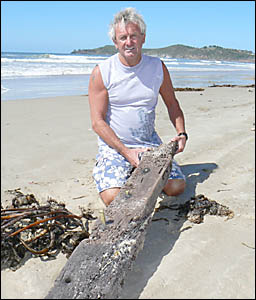 Ken Miles, of Evans Head, with a piece of stem post washed up on the shore at Airforce Beach. Ken Miles, of Evans Head, with a piece of stem post washed up on the shore at Airforce Beach.