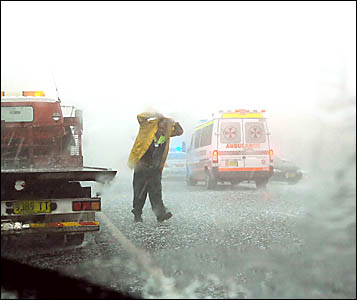SITTING DUCKS: Police and ambulance officers braved the storm to attend a traffic accident in Lismore yesterday afternoon, as t SITTING DUCKS: Police and ambulance officers braved the storm to attend a traffic accident in Lismore yesterday afternoon, as t