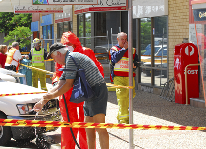 Clean-up...a shopper is washed down by an emergency worker after Woolgoolga Plaza was evacuated yesterday. PHOTO: TREVOR VEALE Clean-up...a shopper is washed down by an emergency worker after Woolgoolga Plaza was evacuated yesterday. PHOTO: TREVOR VEALE