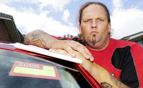 DRIVEN CRAZY: Ballina man Terri Wrigley with the expired rego sticker on the car he hired recently. DRIVEN CRAZY: Ballina man Terri Wrigley with the expired rego sticker on the car he hired recently.