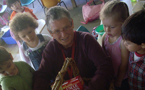 Honu from Liberation Larder (centre) receives a basket of food from children at the Byron Bay Preschool. Honu from Liberation Larder (centre) receives a basket of food from children at the Byron Bay Preschool.