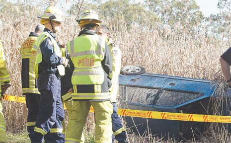FIREFIGHTERS yesterday inspected a car that rolled in vegetation off Piggabeen Road at Tweed Head West. FIREFIGHTERS yesterday inspected a car that rolled in vegetation off Piggabeen Road at Tweed Head West.