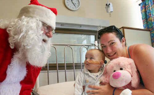 Sophie Stephenson with mum Melita Nelson receives a stuffed toy from Santa Claus yesterday at the Rockhampton Hospital’s children’s ward. Sophie Stephenson with mum Melita Nelson receives a stuffed toy from Santa Claus yesterday at the Rockhampton Hospital’s children’s ward.