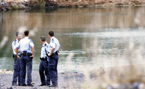 Police gather around the Collingwood Park lake where a 22-year-old man drowned. Police gather around the Collingwood Park lake where a 22-year-old man drowned.