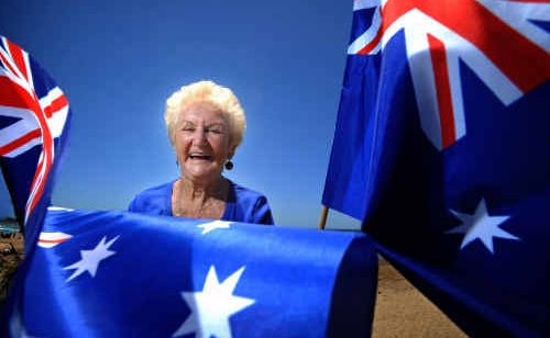 Clarence Valley Citizen of the Year Evelyn Gane waves the flag on Minnie Water beach after the announcement at Australia Day celebrations. Clarence Valley Citizen of the Year Evelyn Gane waves the flag on Minnie Water beach after the announcement at Australia Day celebrations.