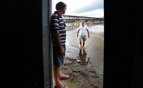 Karl Cooksley and Tony Smith look at the river lapping at the front of the Clarence River Sailing Club. Karl Cooksley and Tony Smith look at the river lapping at the front of the Clarence River Sailing Club.