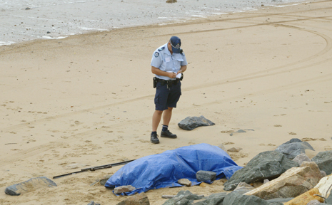 A police officer stands guard after a body washed up on Yeppoon's Main Beach this morning. A police officer stands guard after a body washed up on Yeppoon's Main Beach this morning.