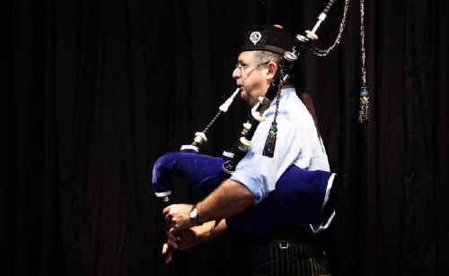 Alastair McInness stands under the stage light while performing in the open hornpipe competition. Alastair McInness stands under the stage light while performing in the open hornpipe competition.