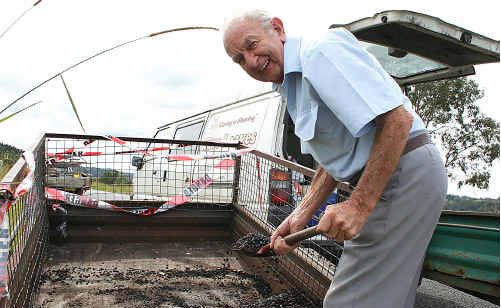 Darcy Goodwin shovels gravel from the busted trailer. Darcy Goodwin shovels gravel from the busted trailer.