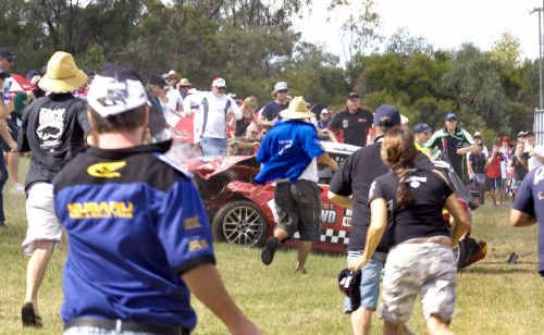 Spectators ran to help injured fans after Kain Magro crashed and flipped over the barrier during race one of the Mini Challenge series at Queensland Raceway. Spectators ran to help injured fans after Kain Magro crashed and flipped over the barrier during race one of the Mini Challenge series at Queensland Raceway.