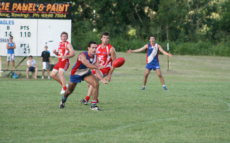 Whitsunday centre half forward Nick O'Reilly dishes off to a team mate in Saturday's thumping of last season's premiers Eastern Swans. Whitsunday centre half forward Nick O'Reilly dishes off to a team mate in Saturday's thumping of last season's premiers Eastern Swans.