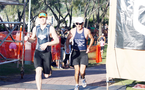 After the swim and the bike ride comes the run. Competitors cross the finish line at last year’s event. After the swim and the bike ride comes the run. Competitors cross the finish line at last year’s event.