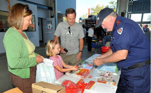 Sawtell fire captain Keith Rhoades packs a bag of goodies for Rebeccah and her parents Andrew and Janine (right). Far left: Firefighter Mick Gibbons demonstrates a fire hose to Sam Melinz of East Boambee. Sawtell fire captain Keith Rhoades packs a bag of goodies for Rebeccah and her parents Andrew and Janine (right). Far left: Firefighter Mick Gibbons demonstrates a fire hose to Sam Melinz of East Boambee.