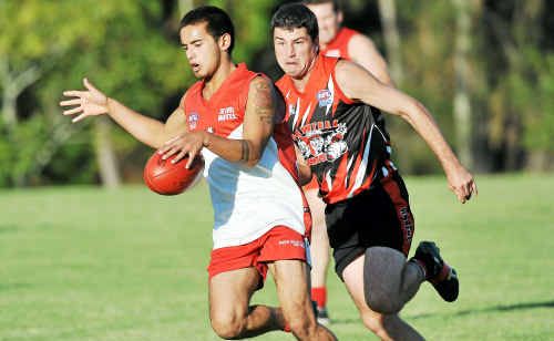 Coffs Swans captain-coach Kris Rundell gets his kick in ahead of Sawtell’s Daniel Pritchard. Coffs Swans captain-coach Kris Rundell gets his kick in ahead of Sawtell’s Daniel Pritchard.