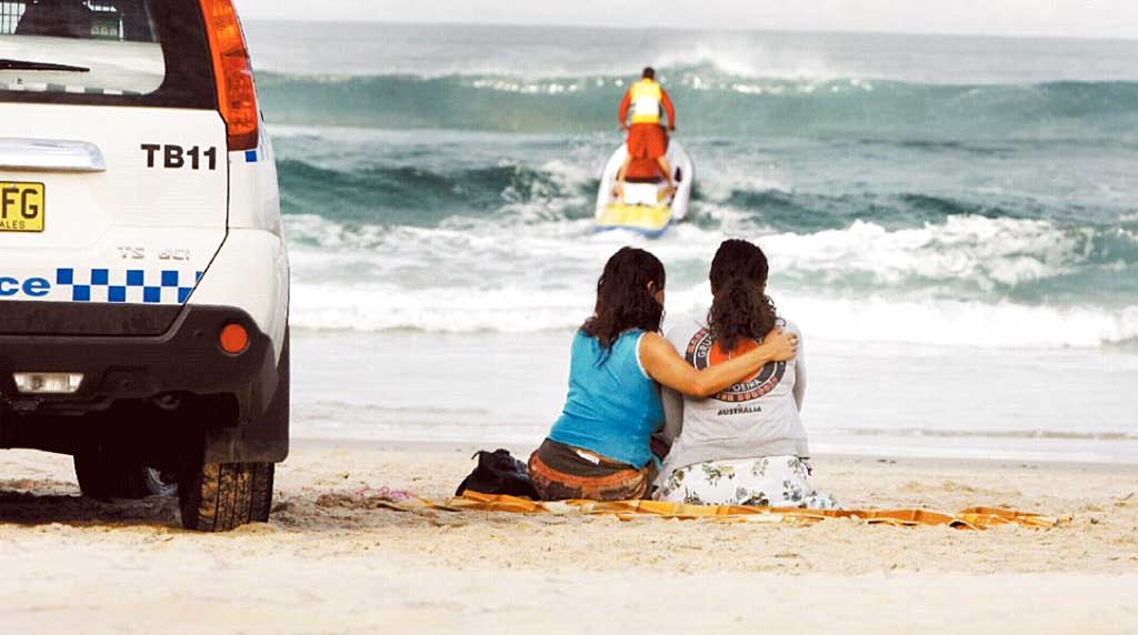 Lifesavers search the surf at Suffolk Park Beach near Byron Baywhile the family of the swimmer waits anxiously on the beach. Lifesavers search the surf at Suffolk Park Beach near Byron Baywhile the family of the swimmer waits anxiously on the beach.