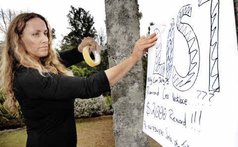 Desperate: Sonia, owner of the missing $20,000 necklace, puts up a poster in Bangalow offering a $2000 reward for its return after losing the piece of jewellery at the Billycart Derby on Sunday. Desperate: Sonia, owner of the missing $20,000 necklace, puts up a poster in Bangalow offering a $2000 reward for its return after losing the piece of jewellery at the Billycart Derby on Sunday.
