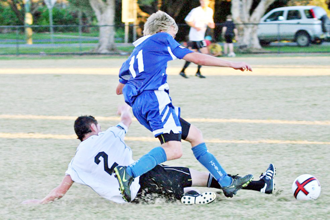 Ben Coulter in a defensive slide tackle. Ben Coulter in a defensive slide tackle.