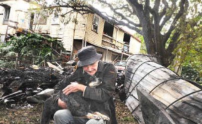 Little Keen Street resident Jimmy Davies, 80, owes his life to his blue heeler Bluey, 13, who woke him because of a caravan fire next to his house (in background). Little Keen Street resident Jimmy Davies, 80, owes his life to his blue heeler Bluey, 13, who woke him because of a caravan fire next to his house (in background).