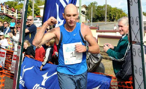 Hervey Bay runner Steven Page pumps his fist as he crosses the finish line to take the individual event at the Old Gympie Railway Station yesterday morning. Page has won the event two years running. Hervey Bay runner Steven Page pumps his fist as he crosses the finish line to take the individual event at the Old Gympie Railway Station yesterday morning. Page has won the event two years running.
